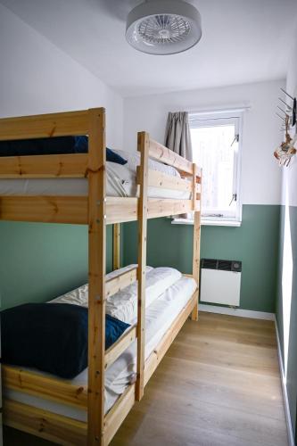 two bunk beds in a room with a window at Waddenhuyske in Hollum