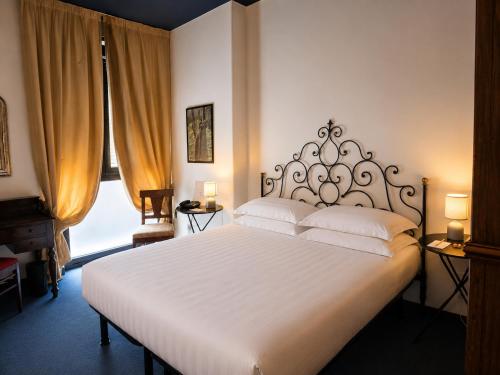 a bedroom with a large white bed with white pillows at Phi Hotel Palio in Asti