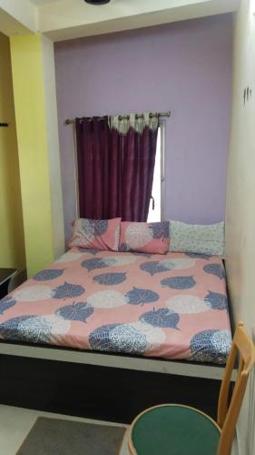 a bed in a room with a window at priyadarshi in Digha