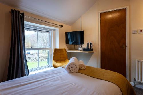 a bedroom with a bed and a large window at Strands Hotel/Screes Inn & Micro Brewery in Nether Wasdale