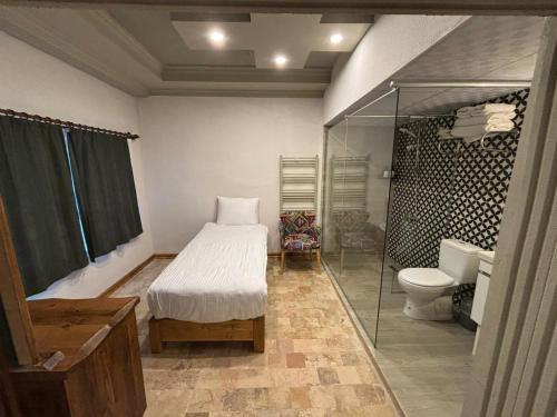 a bedroom with a bed and a toilet and a shower at Grand Elite Cave Suites in Göreme