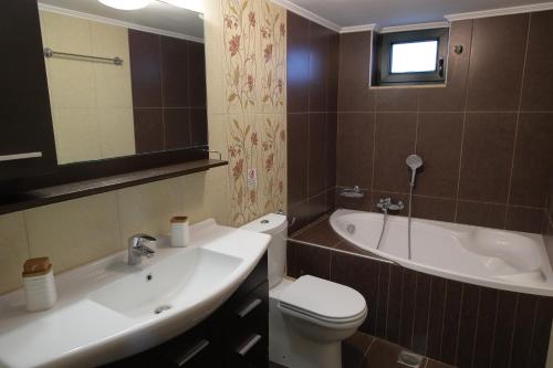a bathroom with a sink and a toilet and a tub at Villa Thea, By IdealStay Experience in Kaloi Limenes