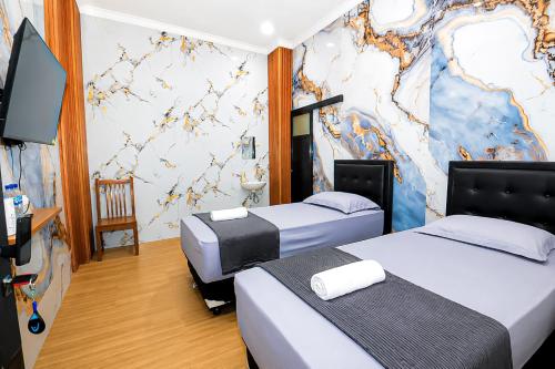 a room with two beds and a wall with a map at Lestari Malioboro Guesthouse in Sentool