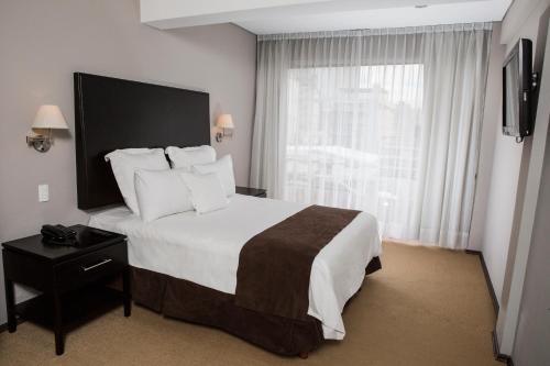 a hotel room with a large bed and a window at Suites Parioli in Mexico City