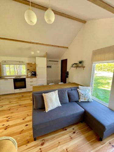 a living room with a blue couch and a kitchen at Rest-Inn Timber-Lake in Kłodno
