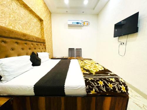 a bedroom with a bed and a tv on the wall at Hotel Embassy In - 200 Mtrs - Near Golden Temple in Amritsar