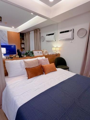 a bedroom with a large bed with orange and white pillows at Gabbys Place in Bacolod