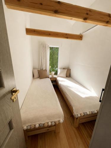 two beds in a room with a window at Rest-Inn Timber-Lake in Kłodno
