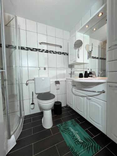 a white bathroom with a toilet and a shower at Allgäuauszeit mit Bergblick - Sauna - Balkon in Scheidegg