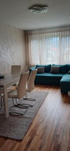 a living room with a table and a blue couch at Шанс in Velingrad
