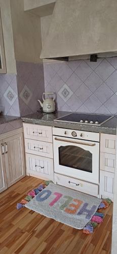 a kitchen with a stove and a rug on the floor at Шанс in Velingrad