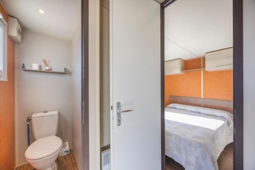a small bathroom with a toilet and a bed at Bungalow Tranquilo Cerca de Roche in Conil de la Frontera