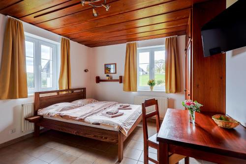 a bedroom with a bed and a table and window at Aparthotel Teddy Kvilda in Kvilda
