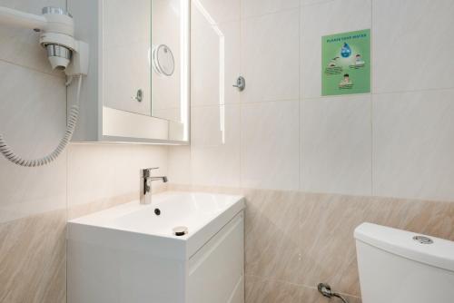 a white bathroom with a sink and a toilet at Apartment Kreta in Strandnähe in Pilalímata