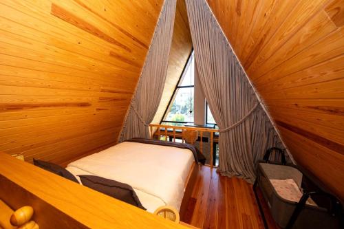 a bedroom with a bed in a room with a window at Begonvil Gümüşlük in Gümüşlük