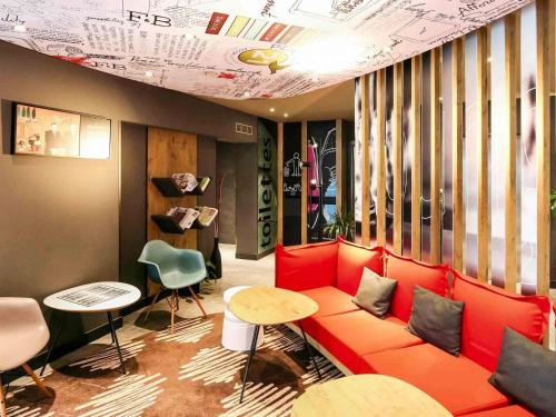 a room with a red couch and a table and chairs at Ibis Irun in Irún