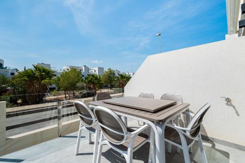 a wooden table and chairs on a balcony at Bungalow Fausto Sunrise in Orihuela Costa