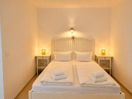 a bedroom with a large white bed with two night stands at Ferienappartement Greta in Lechbruck