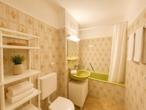 a bathroom with a toilet and a sink and a tub at Ferienappartement Greta in Lechbruck