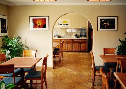 a restaurant with tables and chairs and a kitchen at Days Inn by Wyndham Anaheim Near the Park in Anaheim