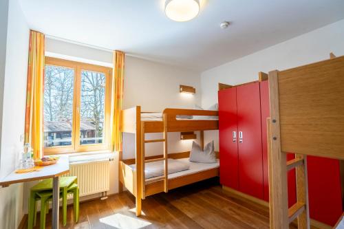 a small room with bunk beds and a table at Jugendherberge Ravensburg in Ravensburg
