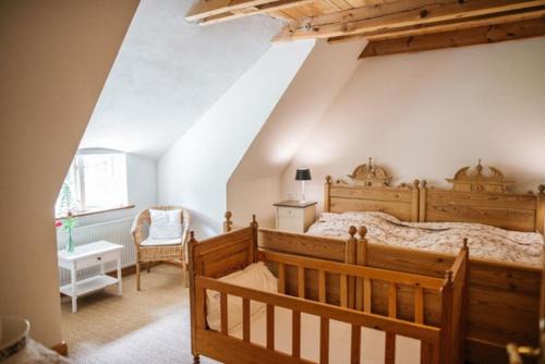a bedroom with a wooden bed and a chair at Hof Lücke - Ferienwohnung Blau in Twedt