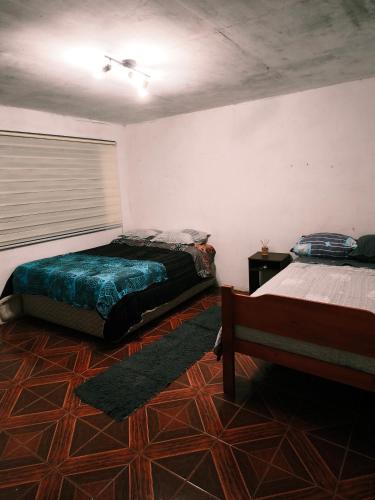 a bedroom with two beds and a window in it at Hare Maohi in Hanga Roa