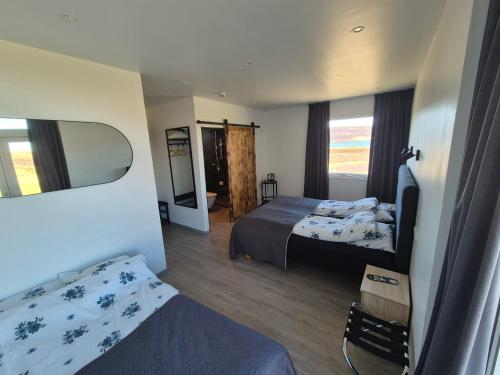 a hotel room with two beds and a mirror at Vestmannsvatn Guesthouse in Aðaldalur