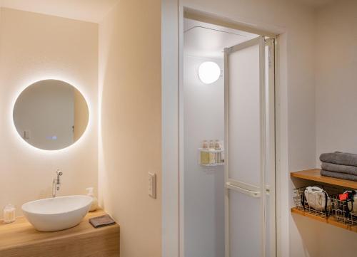 a bathroom with a sink and a mirror at HOTEL Itsuki in Onomichi