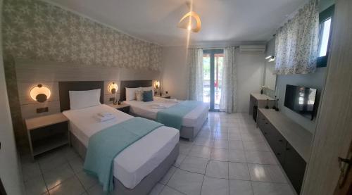 ein Hotelzimmer mit zwei Betten und einem Fernseher in der Unterkunft Apartments Fotoula in Petra