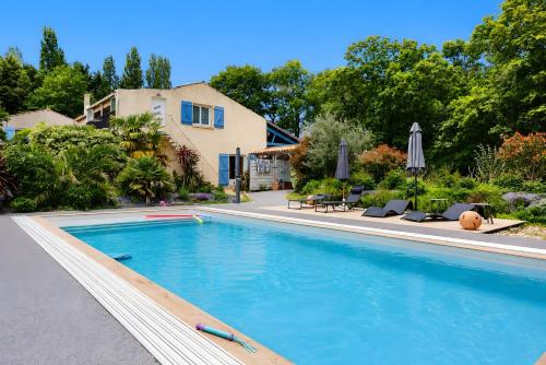 a swimming pool with chairs and a house at Gite Douceur de vivre in Saint-Avaugourd-des-Landes