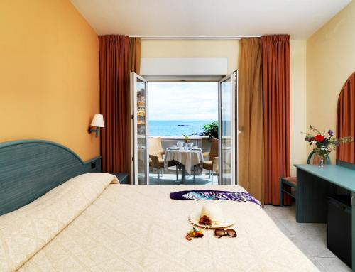 a hotel room with a bed with a view of the ocean at Hotel & SPA Riviera Castelsardo in Castelsardo