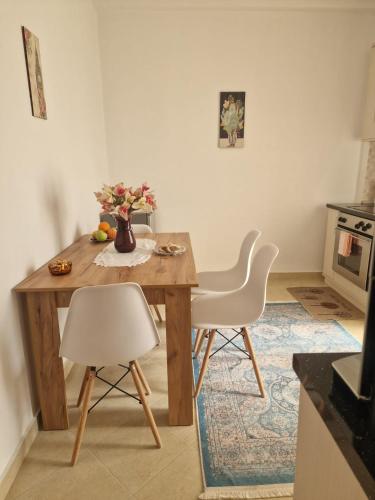 a kitchen with a wooden table and two white chairs at Villa Noah in Berat