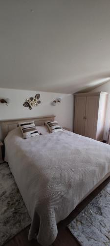 a white bedroom with a large bed in a room at Verde viu in Greşu