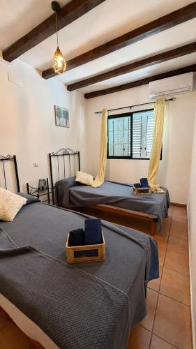 two beds in a room with a window at Alojamientos Rurales La Codosera in La Codosera