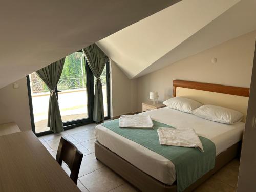 ein Schlafzimmer mit einem Bett und einem großen Fenster in der Unterkunft Avlu Hotel in Kemer