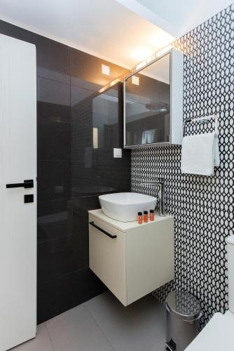a bathroom with a sink and a mirror at Aris by Anita Holiday Homes in Ágios Rókkos