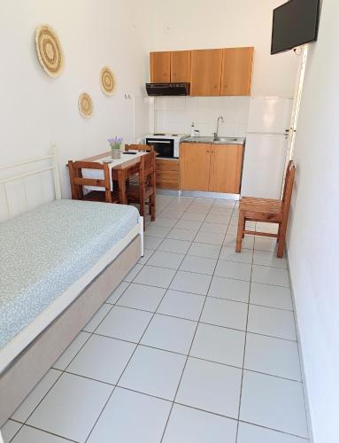 a bedroom with a bed and a table and a kitchen at Villa Christina Sea Side A in Hanioti