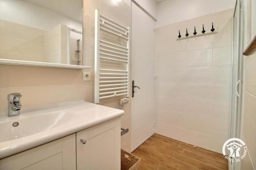 a white bathroom with a sink and a shower at Les sternes in Étel