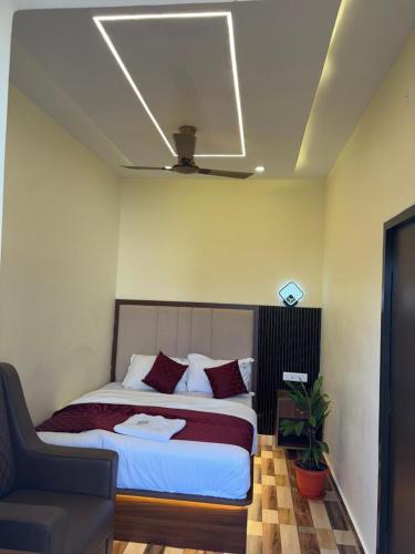 a bedroom with a large bed with red pillows at Hotel Gokulam Grand in Tenāli