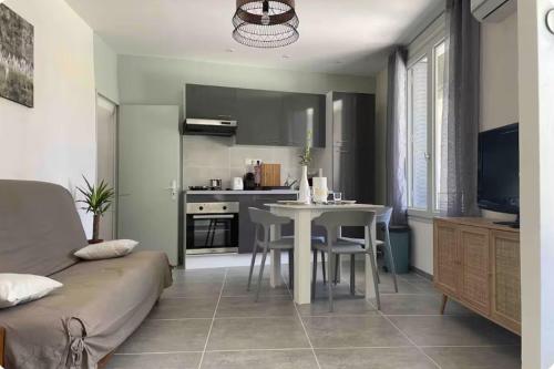 a living room with a table and a kitchen at Sur la route des vignerons - Clim - 1 Chambre in Courthézon