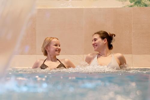 two women are laughing in a hot tub at Strandresidenzen Binz in Binz