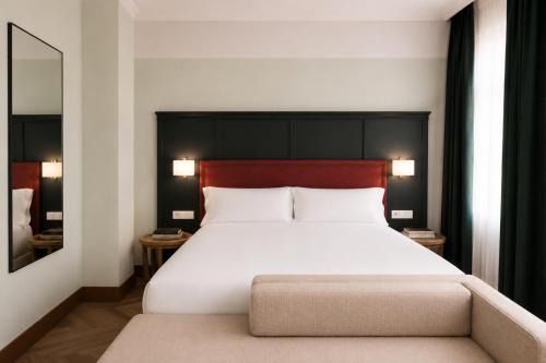 a bedroom with a large white bed with a red headboard at Honest Granada Hotel in Granada