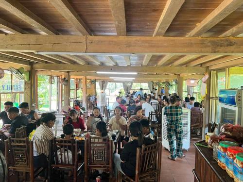 a group of people sitting at tables in a restaurant at Homestay Xuân Sơn 2 in Phú Thọ