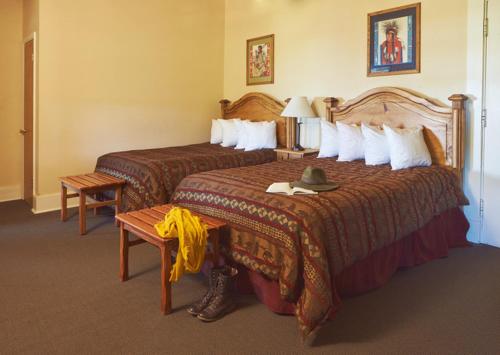 a hotel room with two beds and a hat on top at Glacier Park Lodge in East Glacier Park