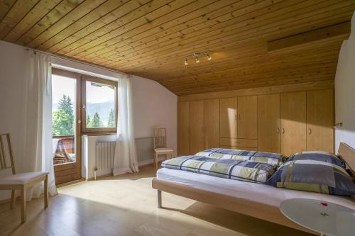 a bedroom with a large bed with a wooden ceiling at Ferienwohnungen Dagn in Kössen