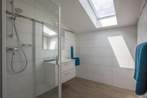 a bathroom with a glass shower and a sink at Ferienwohnungen Dagn in Kössen