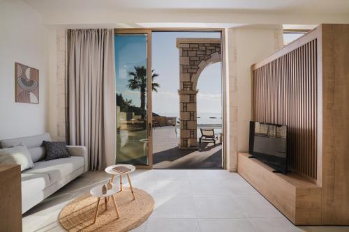 a living room with a couch and a view of the ocean at Alýria Sea Side Suites in Agios Nikolaos