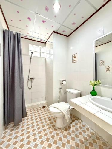 a bathroom with a toilet and a sink and a tub at J Mansion in Ao Nang Beach