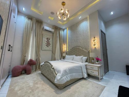 a bedroom with a large bed and a chandelier at Luxury 5 BR Villa with Pool,Cinema Lekki in Lekki